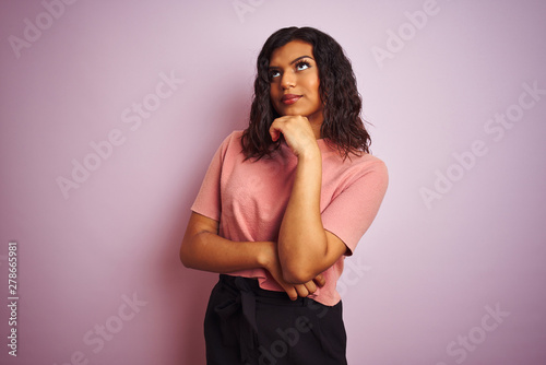 Young beautiful transsexual transgender elegant woman over isolated pink background with hand on chin thinking about question, pensive expression. Smiling with thoughtful face. Doubt concept.