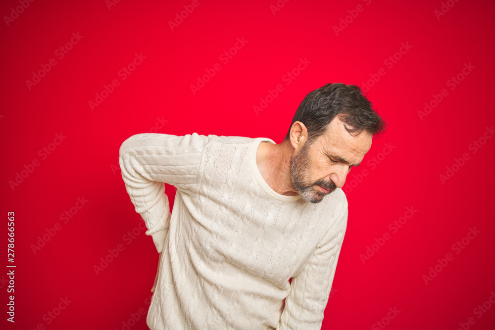 Handsome middle age senior man with grey hair over isolated red background Suffering of backache, touching back with hand, muscular pain Handsome middle age senior man with grey hair over isolated red background Suffering of backache, touching back with hand, muscular pain