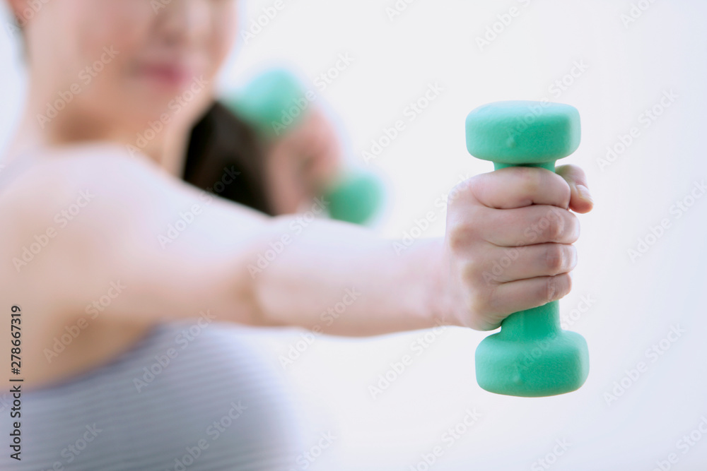 ダンベルを持ち運動する女性