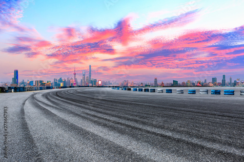 Empty race track and modern city skyline in Shanghai at sunset,China