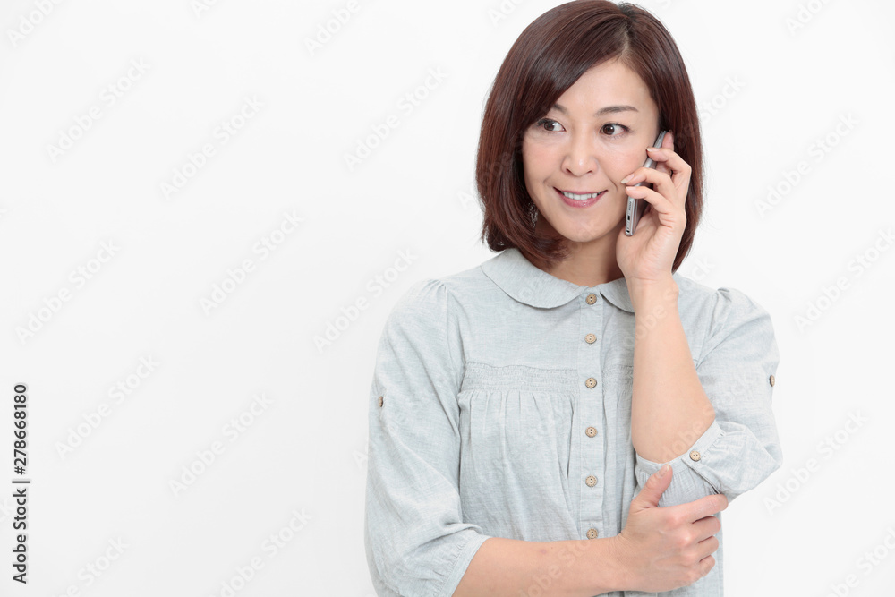 スマートフォンで通話する中年女性 スマートフォンで通話する中年女性