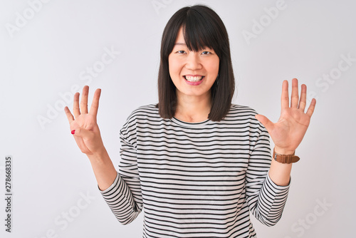 Young beautiful chinese woman wearing black striped t-shirt over isolated white background showing and pointing up with fingers number nine while smiling confident and happy.