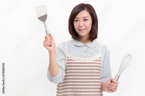 キッチン用品を持つ中年女性