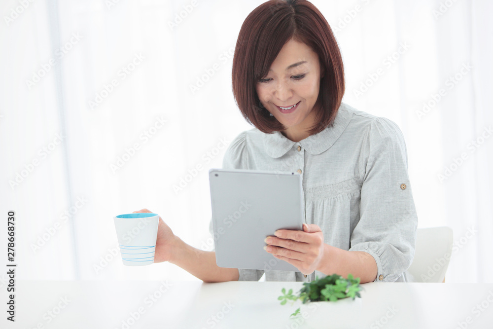 タブレットPCを見る中年女性 タブレットPCを見る中年女性