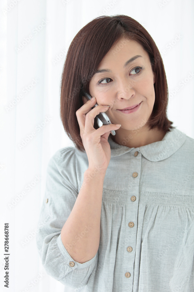 スマートフォンで通話する中年女性