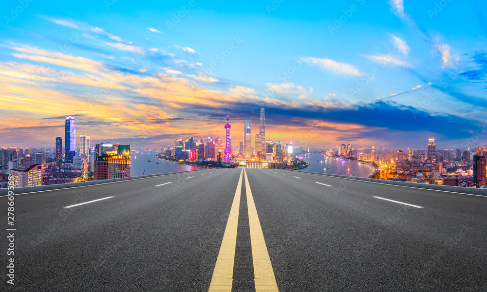 Empty asphalt highway and modern city skyline in Shanghai at sunset,China