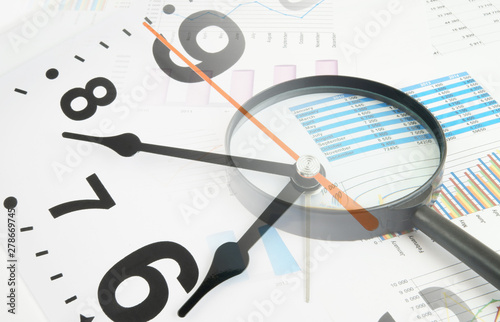 Business concept, magnifying glass on financial charts and graphs, collage with clock
