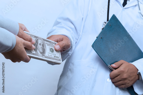 Patient's hand paying a money to doctor