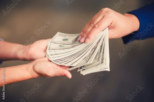 Businessman paying money - United States dollar (USD) bills