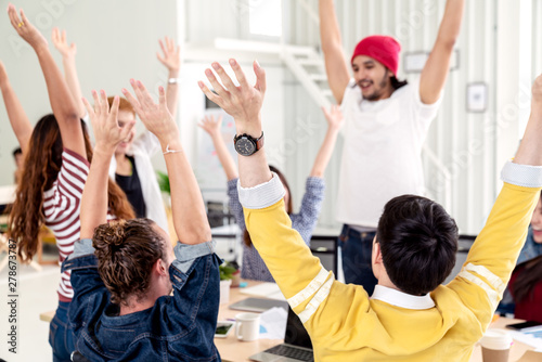 Young multiethnic diverse creative asian group huddle and high five hands together in office workshop with success or empower expression in teamwork. Young happy asian marketing team bonding concept.