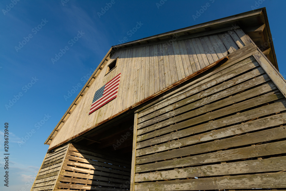 Obraz premium Old wooden barn with American Flag
