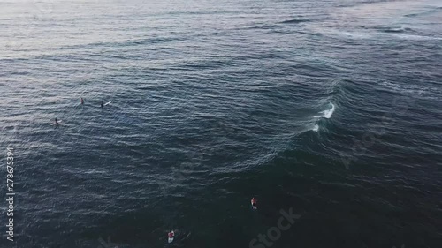 Drone Shot panning over Surfers out in the water off of the North Shore Coast of Oahu, Hawaii. photo