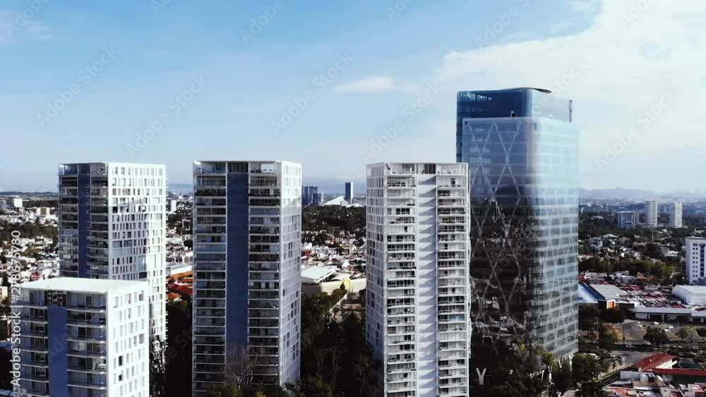 unique tall buildings in a city among low houses during a sunny day unique tall buildings in a city among low houses during a sunny day