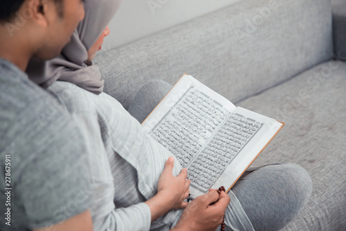 wife and husband learn how to read qoran. muslim family reading holy book of islam