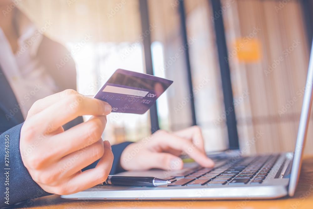 Business woman hand holds a blue credit card.