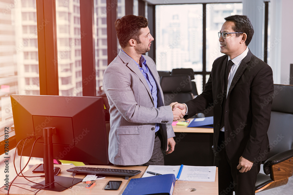 businessman mix race meet smiling and shake hands together in the office businessman mix race meet smiling and shake hands together in the office