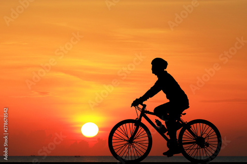 Silhouette  Cycling  on blurry sunrise  sky   background. © rathchapon