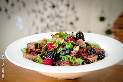Salad bowl with grilled beef steak and berries