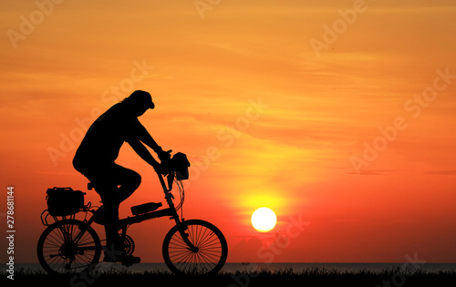Silhouette Cycling on blurry sunrise sky background.