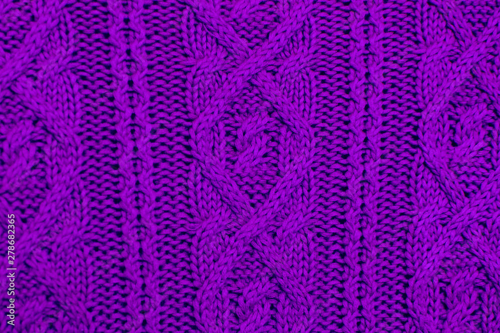 Knit texture of violet wool knitted fabric with cable pattern as background. Ultra Violet texture.