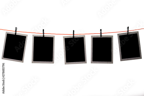 Blank Polaroid pictures hanging in a line on white background