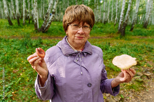 an elderly woman with mushrooms in the woods