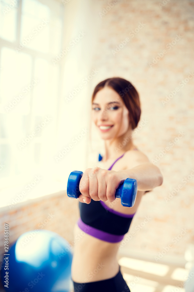 Girl exercising with dumbbells, at home