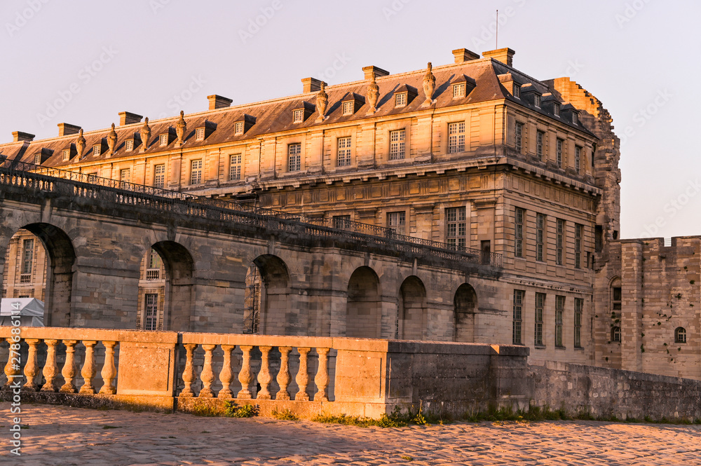 Vincennes Castle at sunset in the rays of the sun. An ancient castle in the south of France. Architecture and travel.