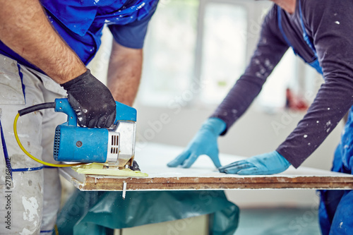 Two handymen working together on a house renovation.