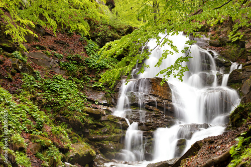 Powerful waterfall on the mountain river Carpathians in Ukraine.