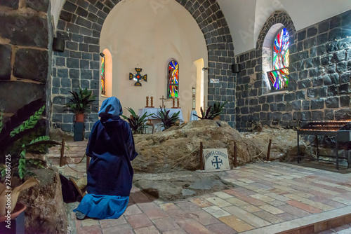 Tabgha, Israel - May 18 2019: Nun praying in the Church of the multiplication of the loaves and fishes in Tabgha, Israel