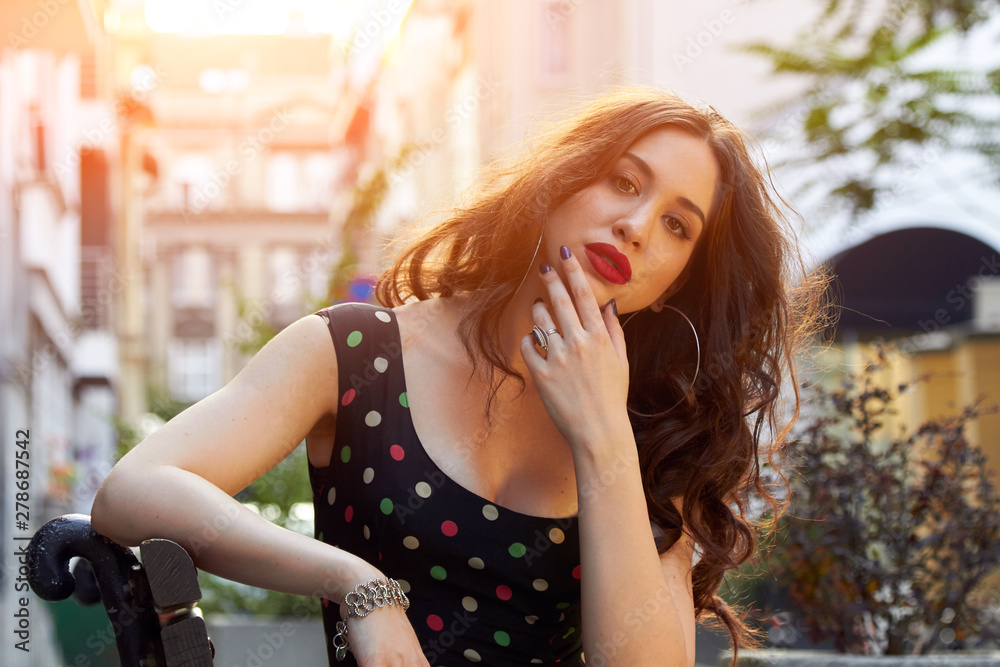Young woman in dress posing on the city / street bench. Young woman in dress posing on the city / street bench.