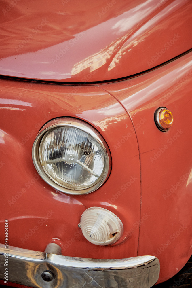 Vista detalle de un coche antiguo típico de Italia en color rojo