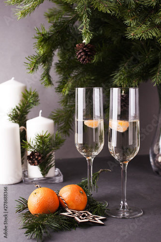 Two champagne glasses, Merry Christmas fir branchs, candles, card for new year greeting
