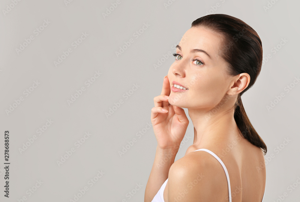 Beautiful young woman with eyelash extensions on grey background Beautiful young woman with eyelash extensions on grey background