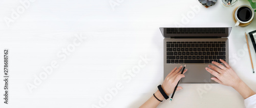 Female writer typing using laptop keyboard and wood copy space photo