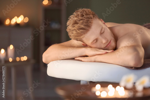 Handsome young man relaxing in spa salon