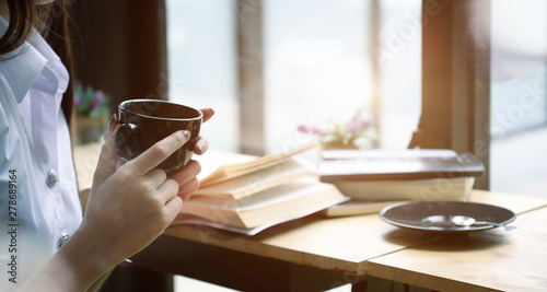 Cropped shot of girl having a break with coffee after reading books