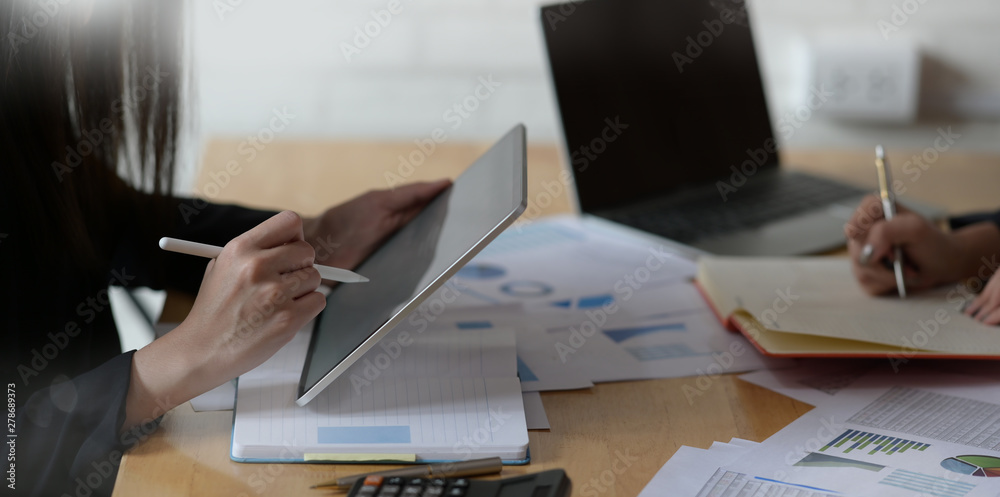 Business woman using tablet with pencil while working at office - obrazy, fototapety, plakaty 