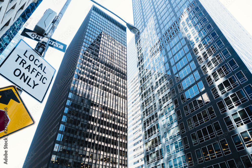 Fototapeta premium Glass high skyscrapers and road sign on street