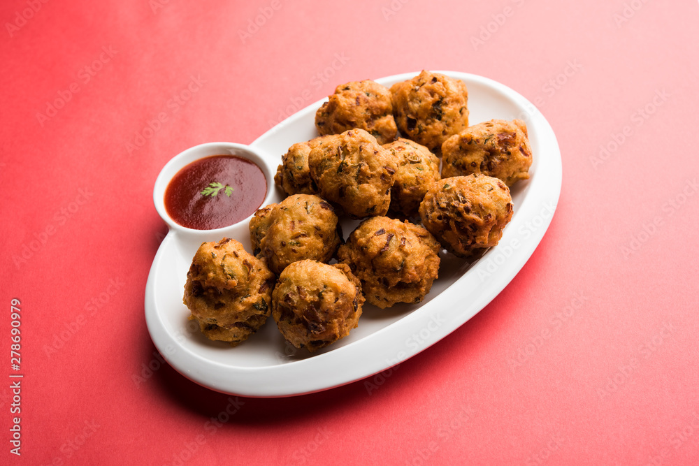 rava Bhajj or bhajiya also known as suji Pakoda or semolina Pakora, served with tomato ketchup. selective focus rava Bhajj or bhajiya also known as suji Pakoda or semolina Pakora, served with tomato ketchup. selective focus