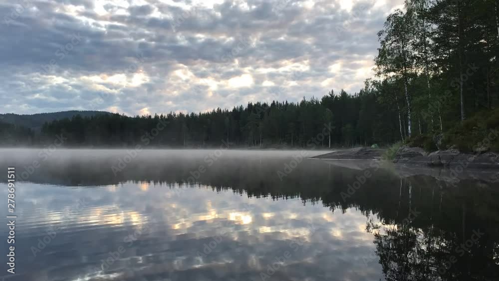 4K timelapse video of fog mist drifting over beautiful and calm lake fjord during sunrise golden hour in Maridalen in Oslo, Norway. 4K timelapse video of fog mist drifting over beautiful and calm lake fjord during sunrise golden hour in Maridalen in Oslo, Norway.
