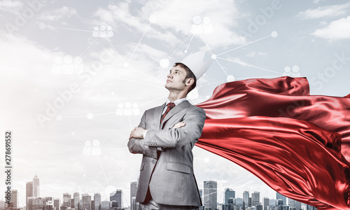 Concept of power and sucess with businessman superhero in big city