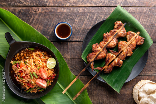 Grilled chicken Thailand style with sticky on wooden table background. som tum concept. Top view.