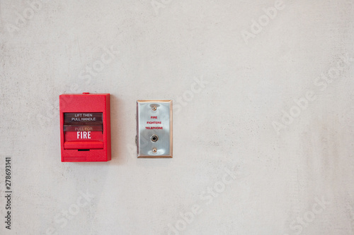 Red fire alarm trigger on the wall with outlet for fire fighter telephone. © mrwinn