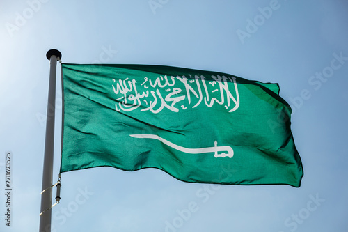 Saudi Arabian flag waving against clear blue sky