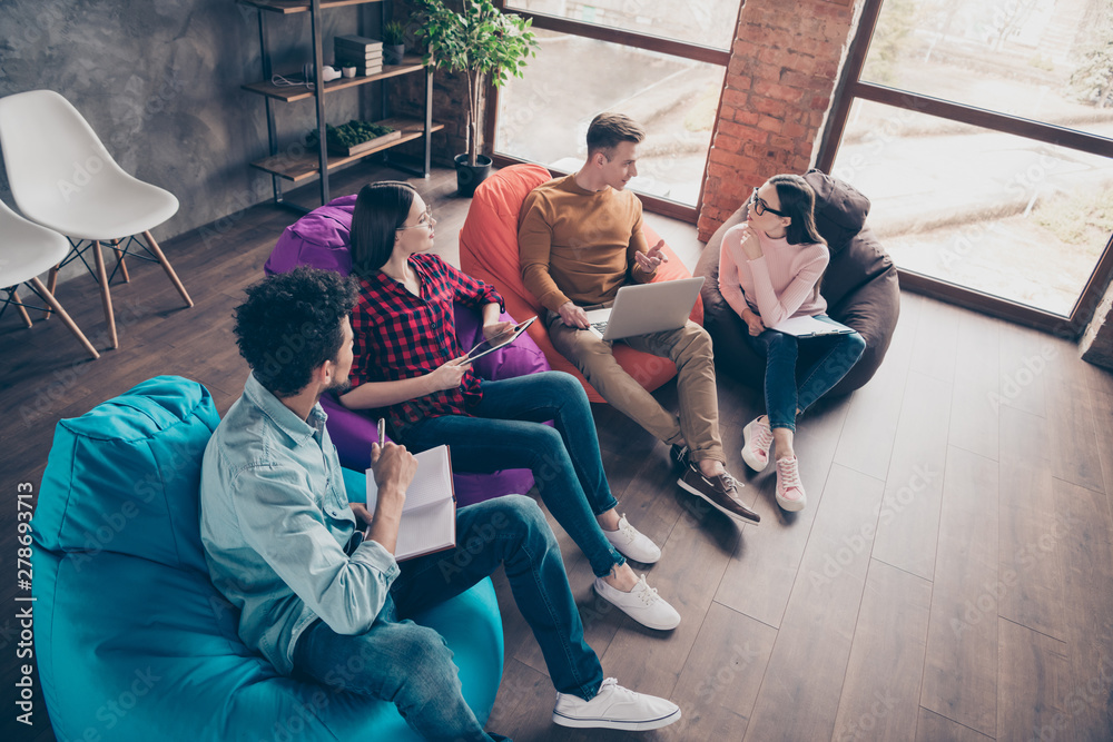 Fototapeta premium Above high angle view of cheerful stylish guys on bag chair managers preparing marketing data research report study education interns at industrial wooden loft interior workplace workstation