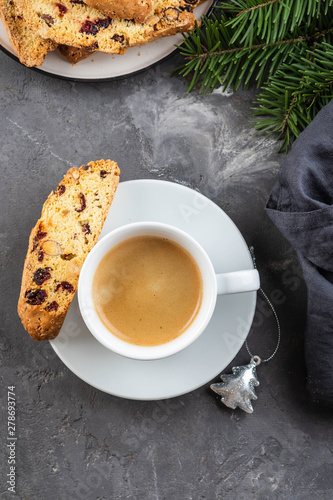 Traditional Christmas pastries, Italian homemade double-baked biscotti or cantuccini cakewith coffee, with nuts and dried fruits. with xmas decorations and fir branches. photo