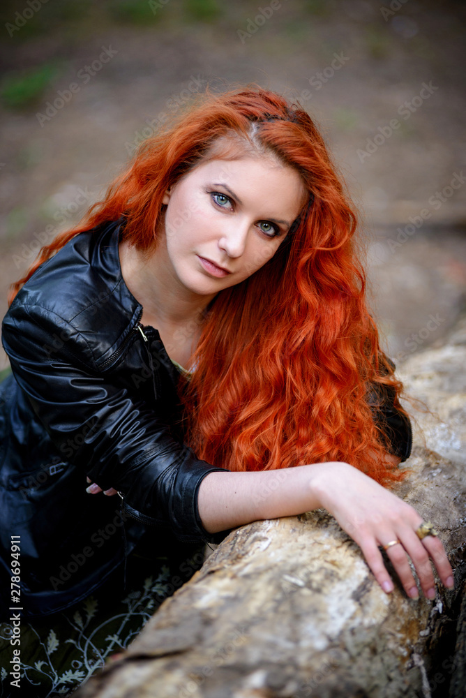 Pretty young sexy fashion sensual red hair woman posing in a forest  background dressed in hipster rock style outfit, leather jacket. foto de  Stock | Adobe Stock