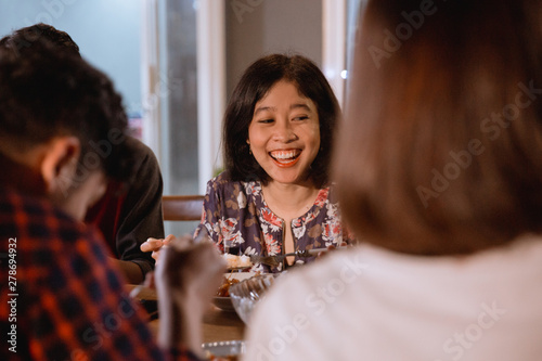 smiling asian woman enjoying their garden dinner party with friend